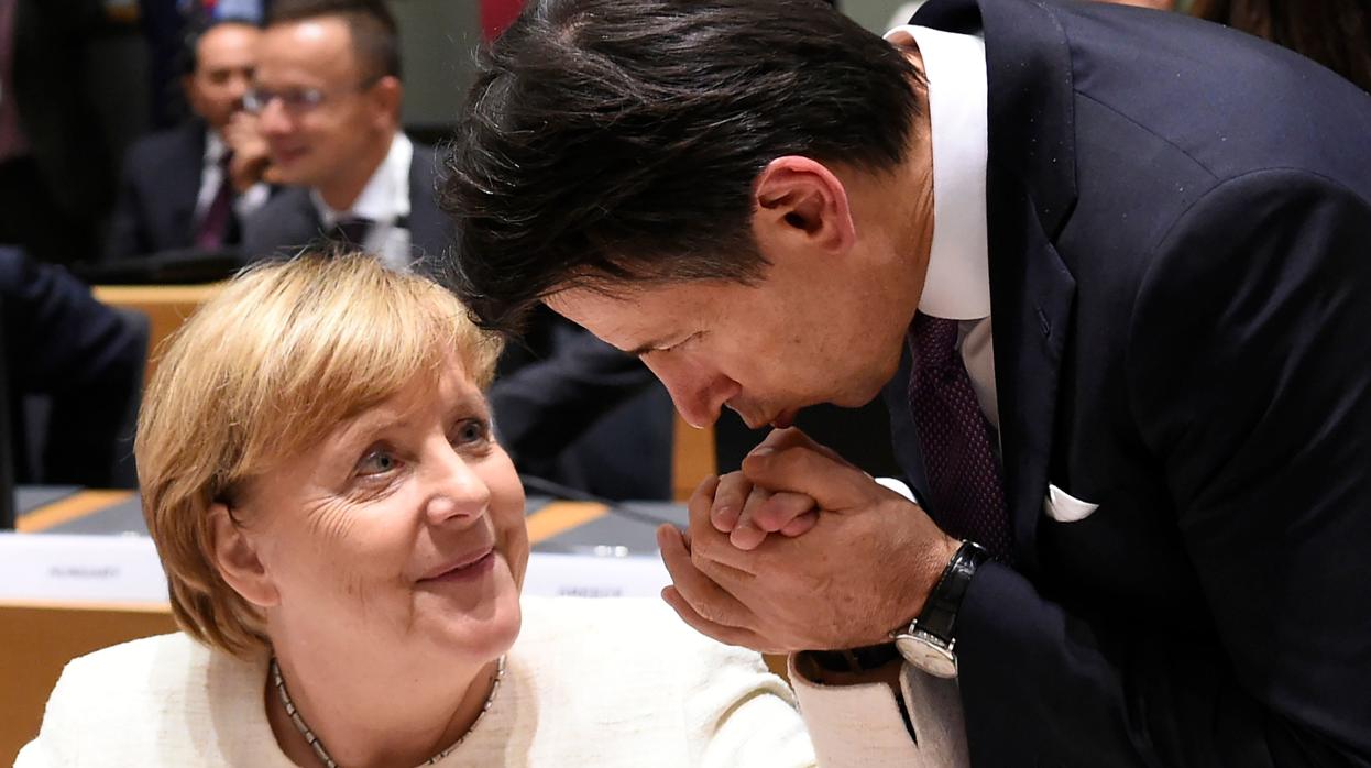 El primer ministro italiano, Giuseppe Conte, besa la mano de la canciller alemana, Angela Merkel, este jueves