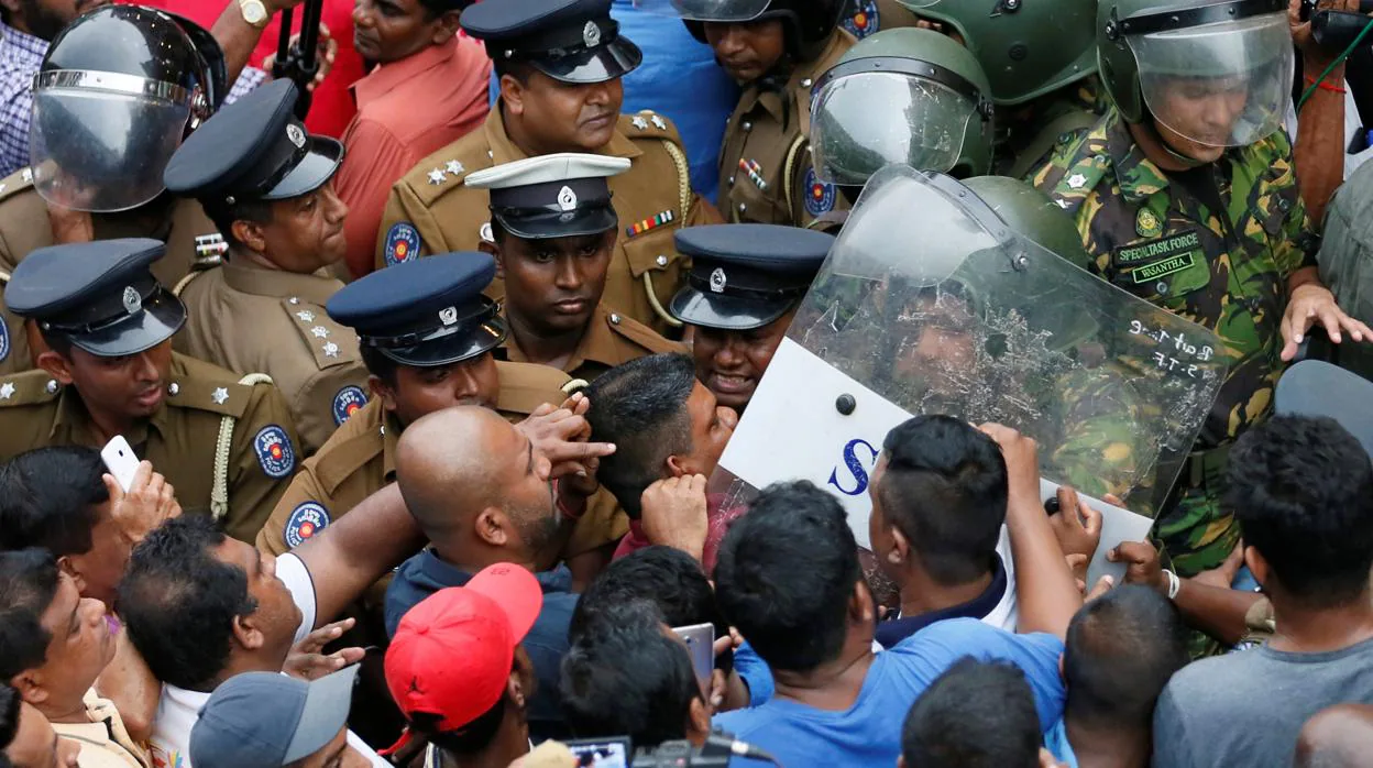 Seguidores del nuevo primer ministro de Sri Lanka, Mahinda Rajapaksa, empujados por las fuerzas de seguridad en Colombo