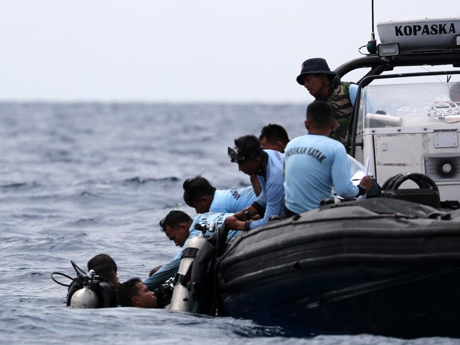 Miembros de los servicios de rescate trabajan en la recuperación de los restos del avión accidentado en el mar de Java cerca de la costa indonesia