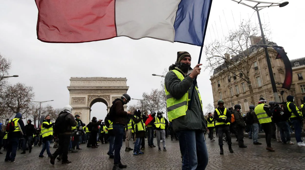 Un chaleco amarillo protesta junto al Arco del Triunfo de París