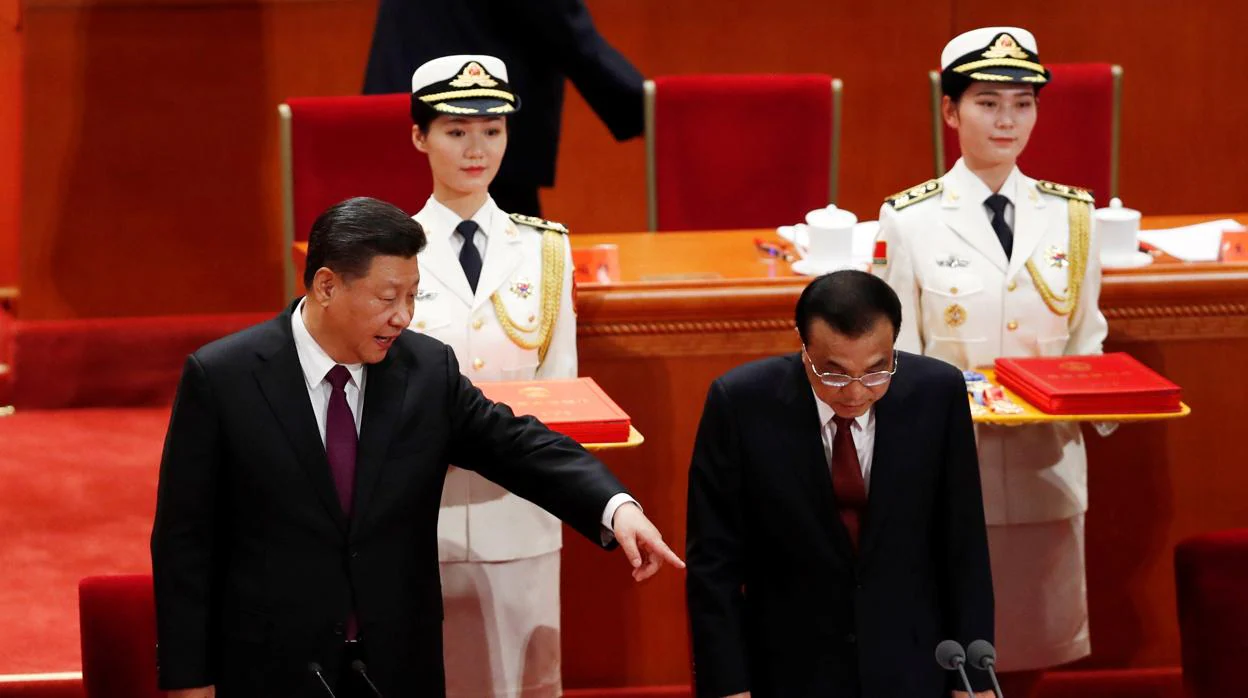 El presidente chino, Xi Jinping (izquierda), hace una indicación al primer ministro chino, Li Keqiang