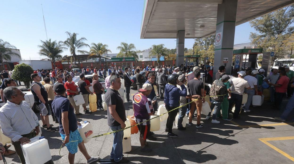 Cientos de personas esperan hoy su turno para lograr obtener unos litros de gasolina en la ciudad de Morelia, en el estado de Jalisco
