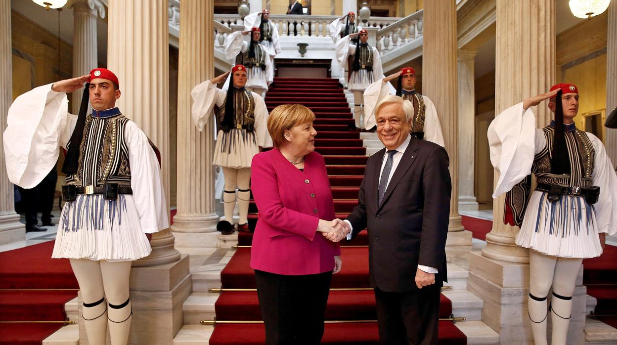 El presidente griego, Prokopis Pavlopoulos (d), recibe a la canciller alemana, Angela Merkel (i), en Atenas (Grecia)