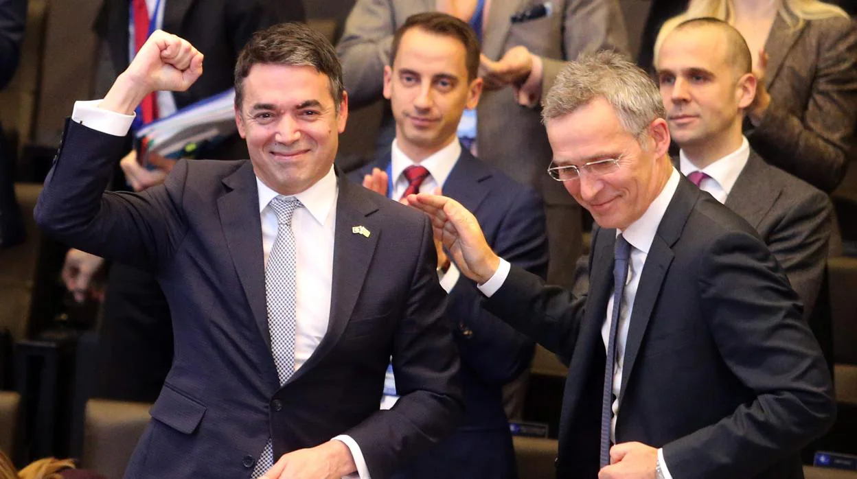 El ministro macedonio de Asuntos Exteriores, Nikola Dimitrov, levanta el puño ante el secretario general de la OTAN, Jens Stoltenberg