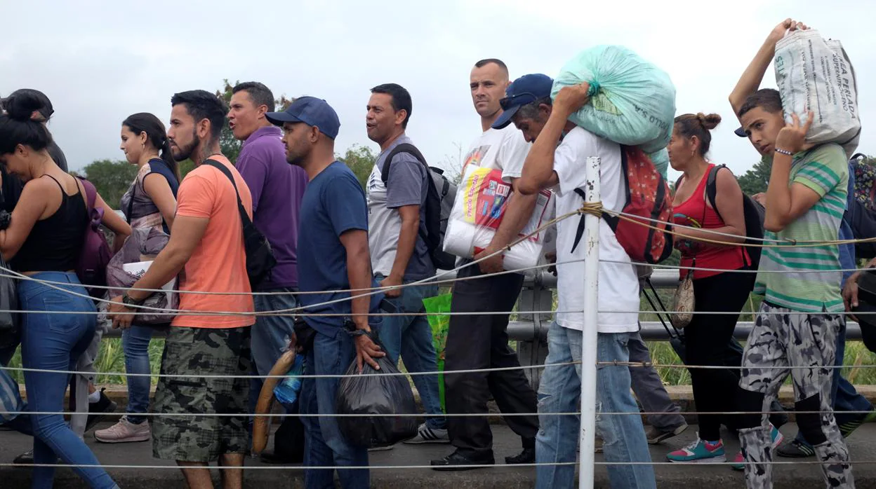 Un grupo de venezolanos cruzan el puente de Simón Bolivar, que separa la frontera de Venezuela con Colombia, tras haberse aprovisionado en Cúcuta