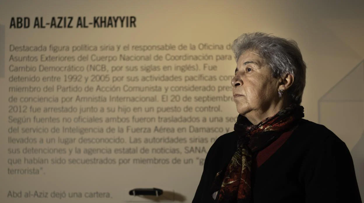Fadwa Mahmour posa delante de la réplica de la cartera de su marido, Abd al Aziz al Khayyir, en la exposicóón «Decenas de miles«, que se puede ver en la Casa Árabe