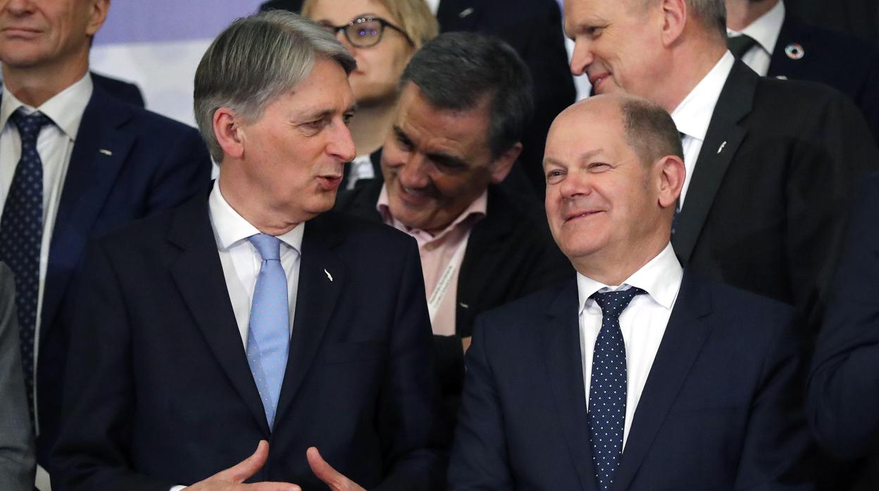 El ministro británico de Economía, Philip Hammond (d), charla con su homólogo alemán, alemán, Olaf Scholz, durante la foto de familia de la reunión informal de ministros de Finanzas de la UE celebrada este viernes en Bucarest