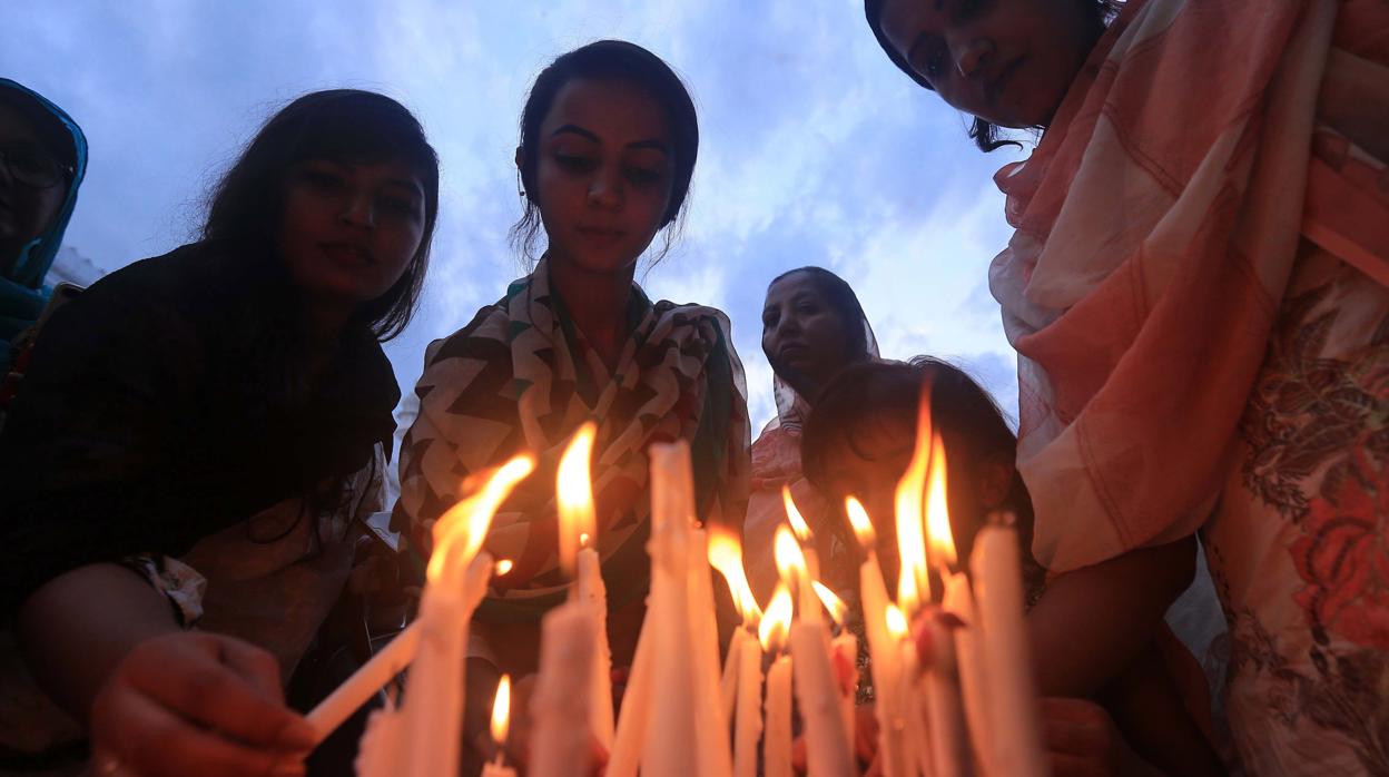 Unas mujeres encienden velas en memoria de las víctimas de Sri Lanka