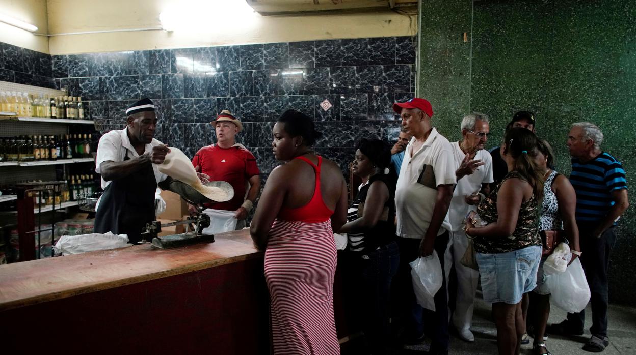 Un grupo de personas hace cola para comprar arroz en un establecimiento estatal