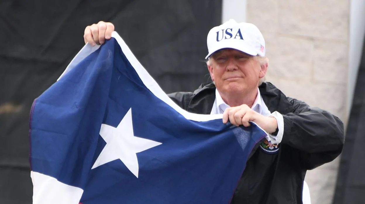 Donald Trump posa con una bandera de Texas, en 2017