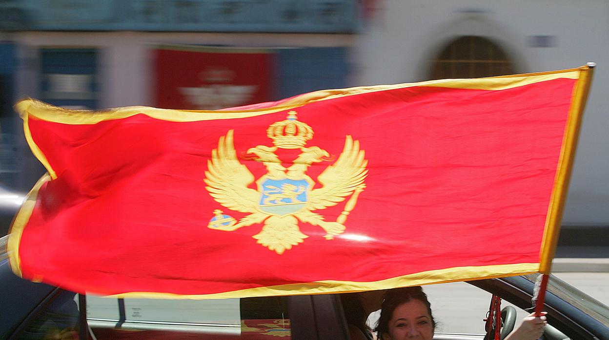 Una mujer sostiene la bandera de Montenegro tras la victoria del bloque independista en 2006