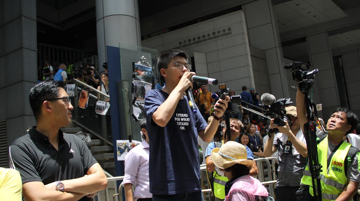 El popular líder estudiantil Joshua Wong arenga a los jóvenes concentrados ante la comisaría central de Hong Kong