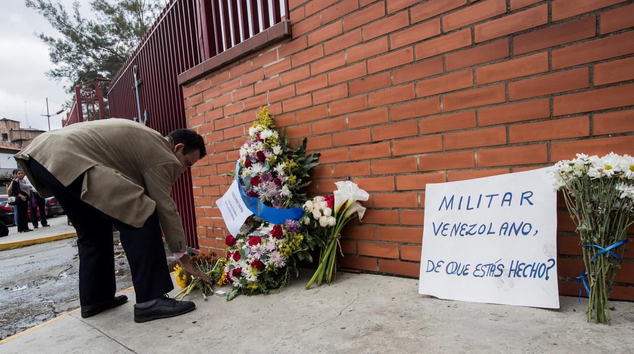 Un hombre deja una ofrenda floral en la entrada del Comando General de la Armada Bolivariana este lunes en honor al capitán venezolano, Rafael Acosta Arevalo