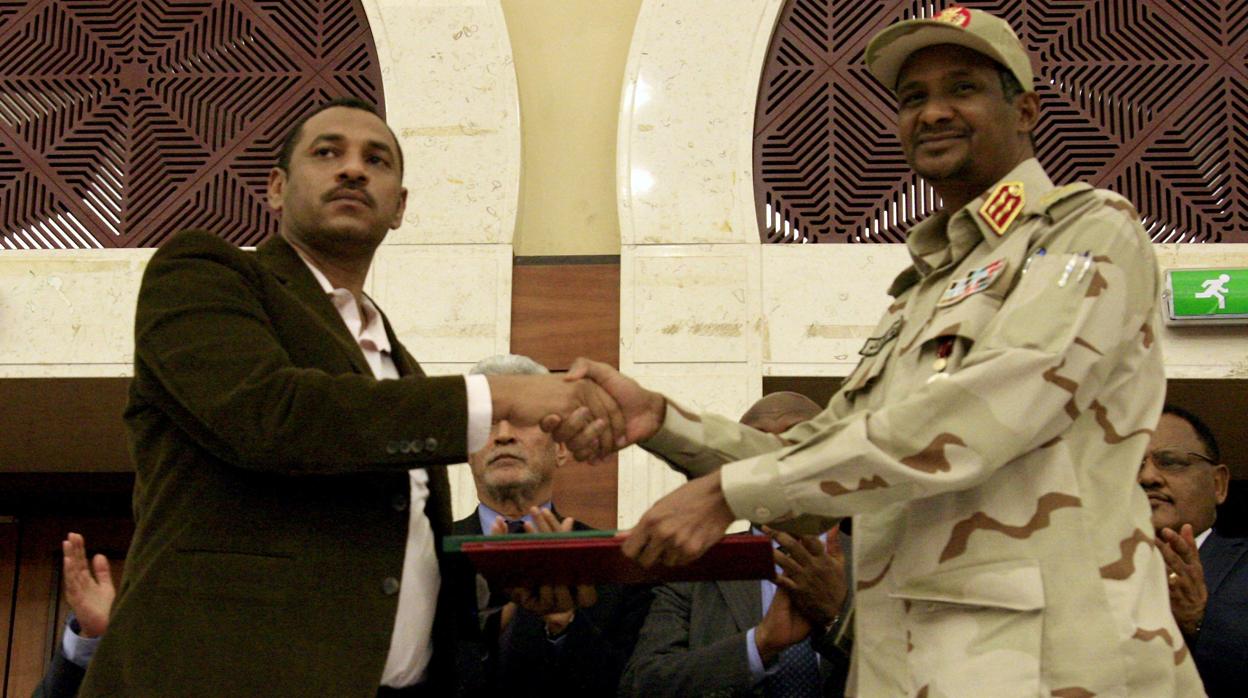 El vicepresidente de la junta militar, Mohamed Hamdan Dagalo (derecha), estrecha la mano del líder de la oposición sudanesa, Ahmad al-Rabiah, tras firmar el acuerdo, hoy en Sudán