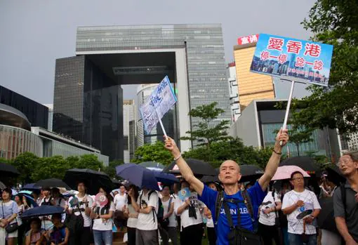 Un manifestante muestra carteles apoyando a las autoridades y contra la violencia desatada en las protestas contra la ley de extradición a China