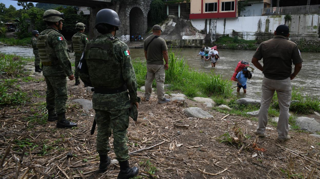 Una patrulla fronteriza mexicana observa a varios emigrantes cruzar el río Suchiate, que separa México de Guatemala, la semana pasada