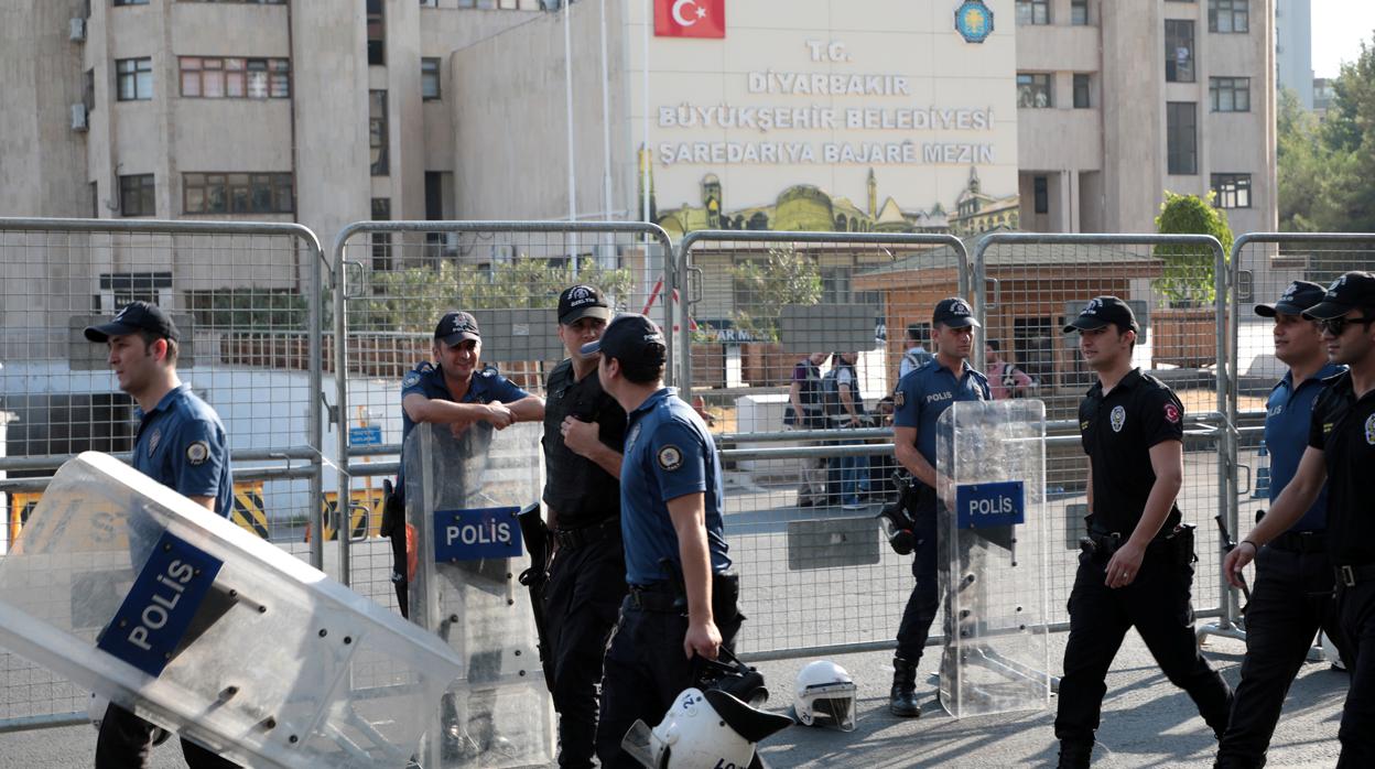 Agentes de la Policía turca caminan frente a la sede municipal de Diyarbakir, hoy