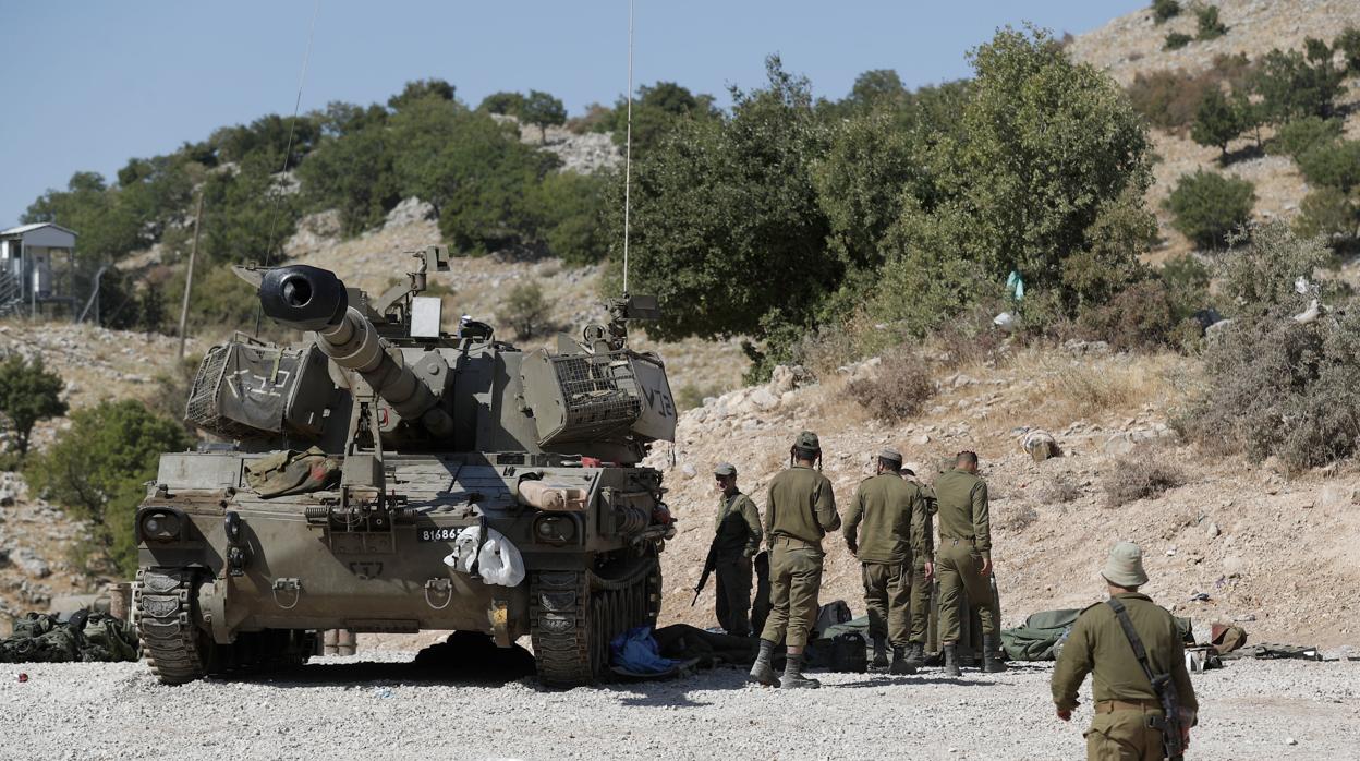 Soldados israelíes junto a un carro de combate en los Altos del Golán, en la frontera entre Israel y Siria