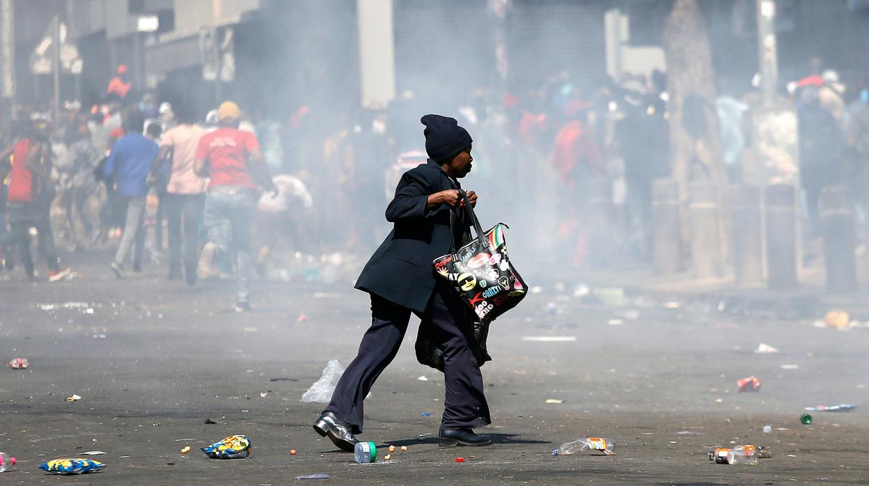 Una mujer camina durante disturbios en Pretoria
