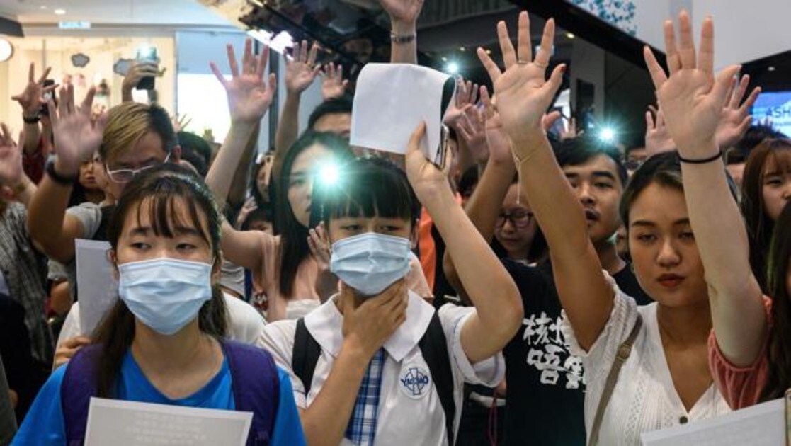 Manifestantes prodemocracia se reúnen en un centro comercial de Hong Kong para cantar el himno