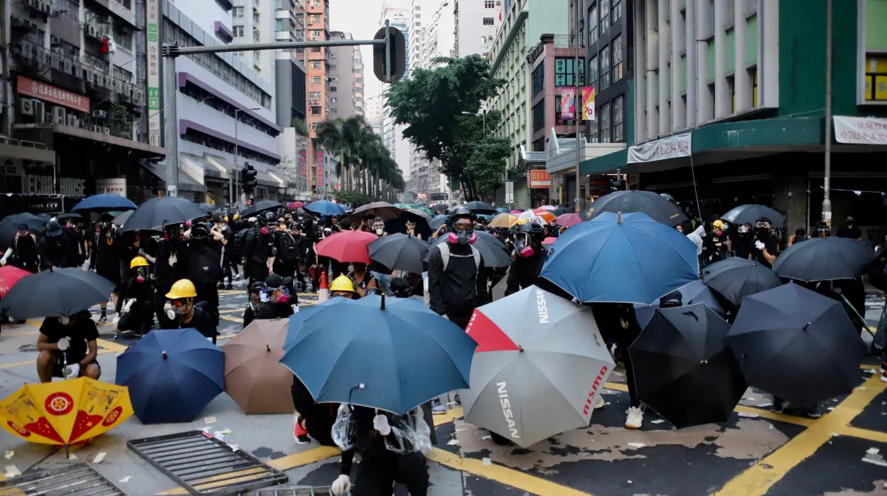Los manifestantes, en su mayoría jóvenes y adolescentes, se parapetan tras sus paraguas, símbolos de la revuelta de Hong Kong