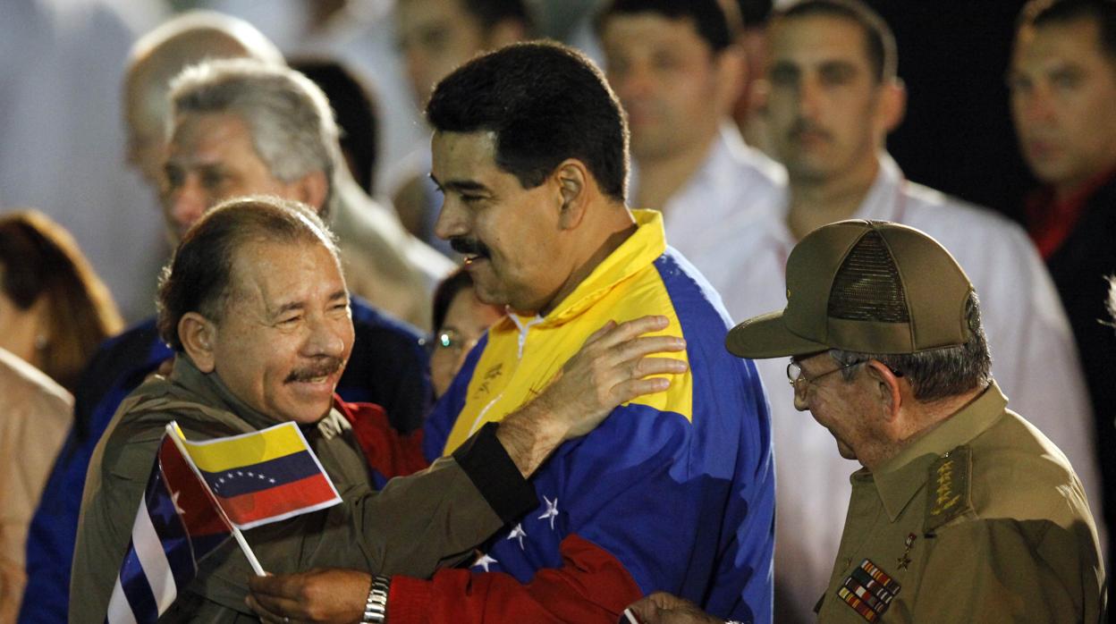 El presidente de Nicaragua, Daniel Ortega abraza a su homólogo venezolano, Nicolás Maduro, mientras el presidente de Cuba, Raúl Castro, observa a los dos líderes