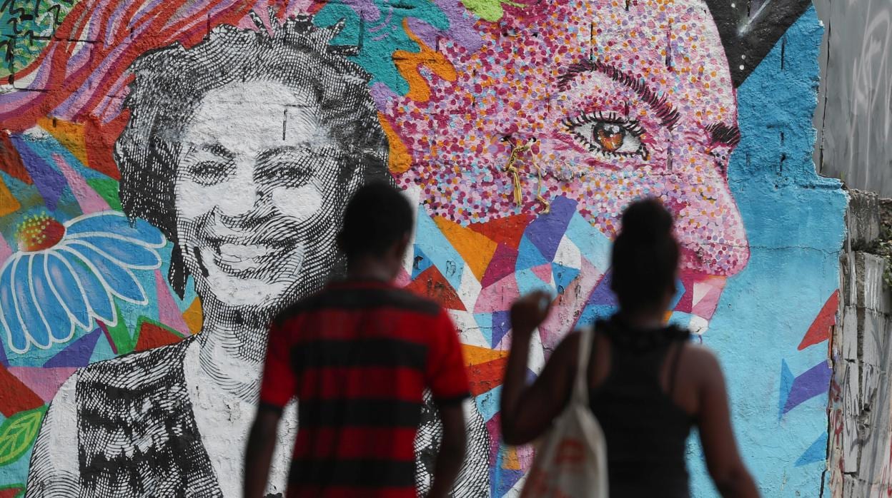Varias personas camina delante de un mural dedicado a la concejala asesinada Marielle Franco, En Río de Janeiro