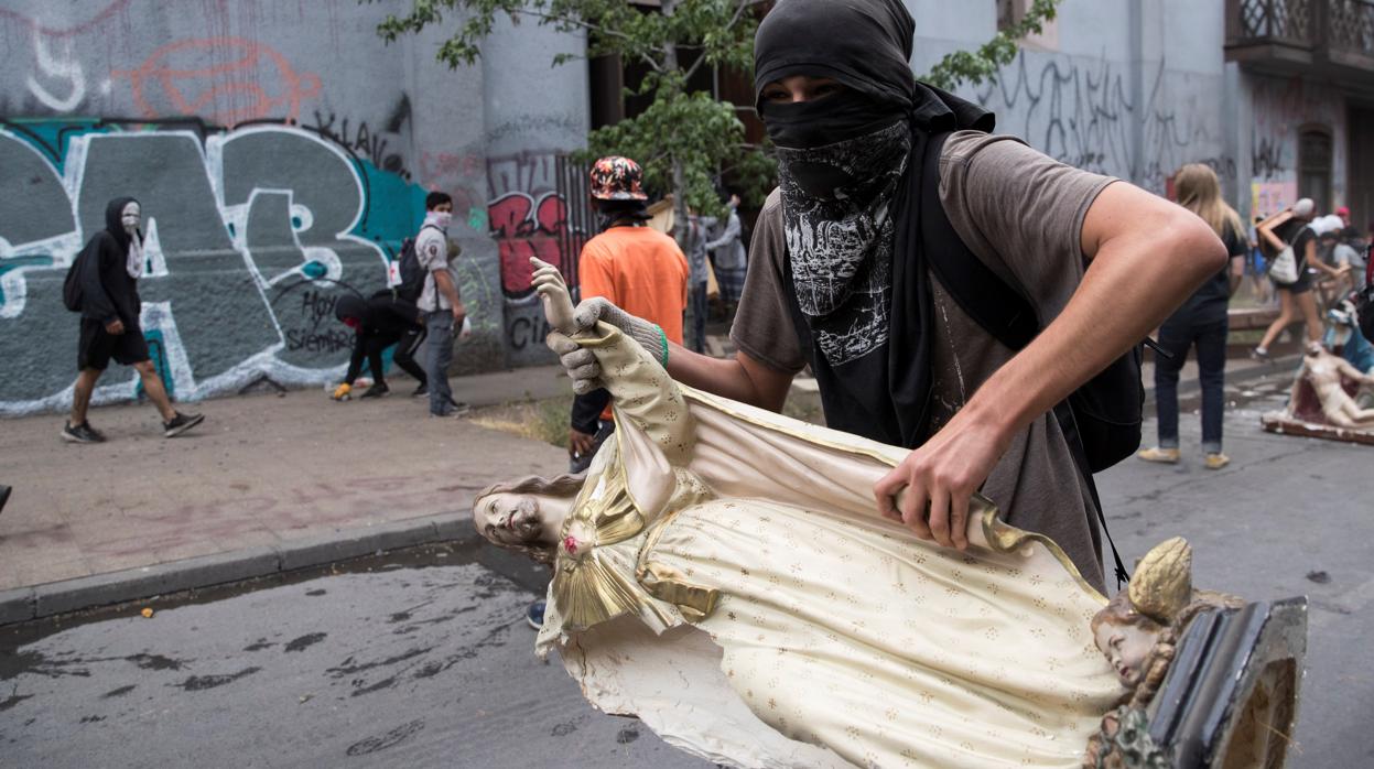 Manifestantes sacan imágenes de la parroquia de La Asunción en una protesta en Santiago de Chile