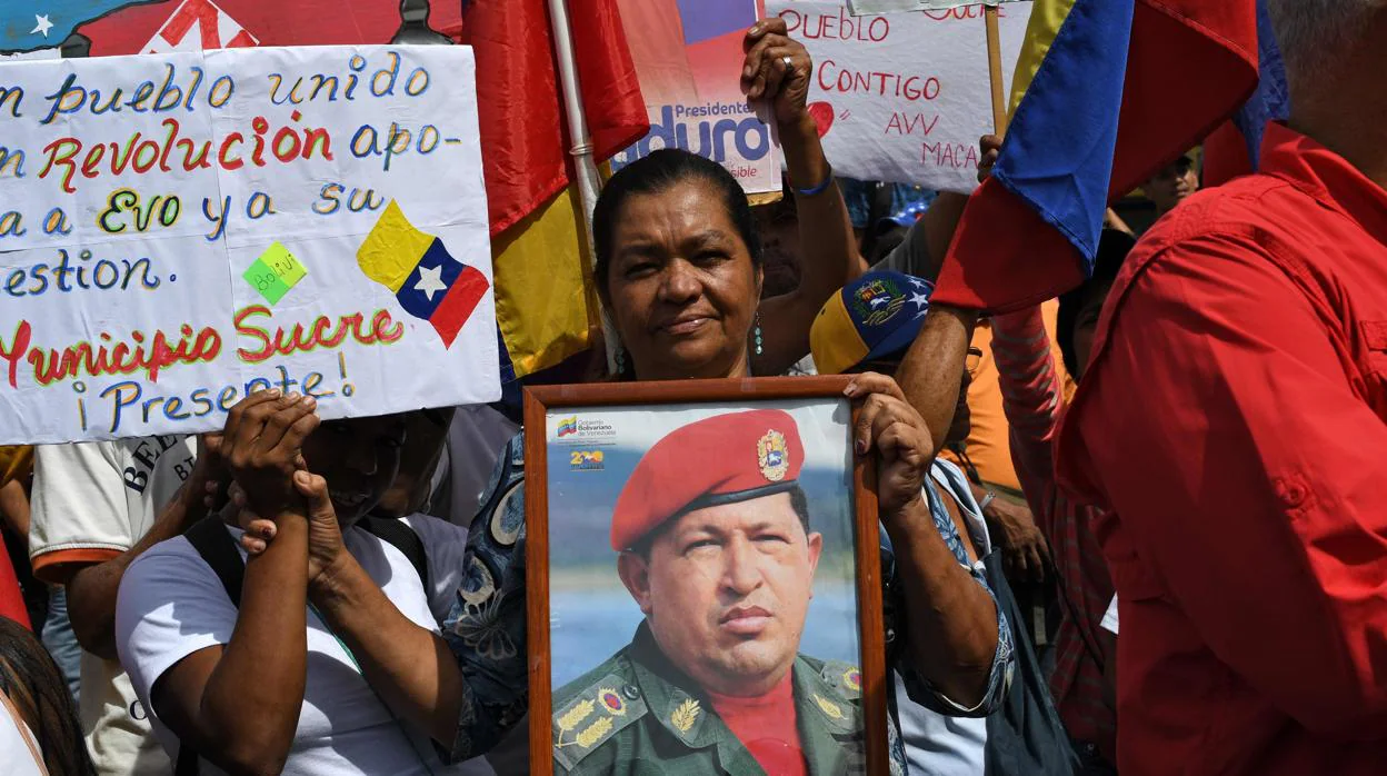 Una mujer sostiene un retrato de Hugo Chávez durante la marcha celebrada hoy por el régimen de Maduro en Caracas