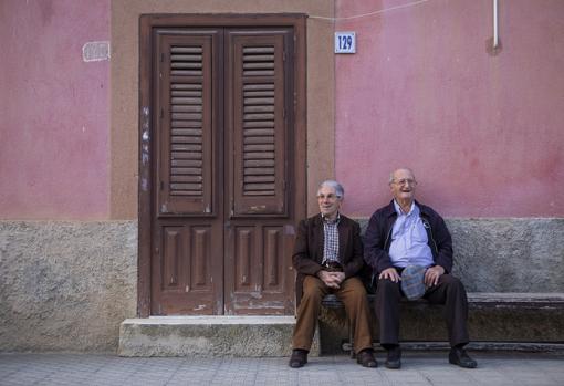 Dos ancianos sentados junto a una casa en Campofelice di Fitalia