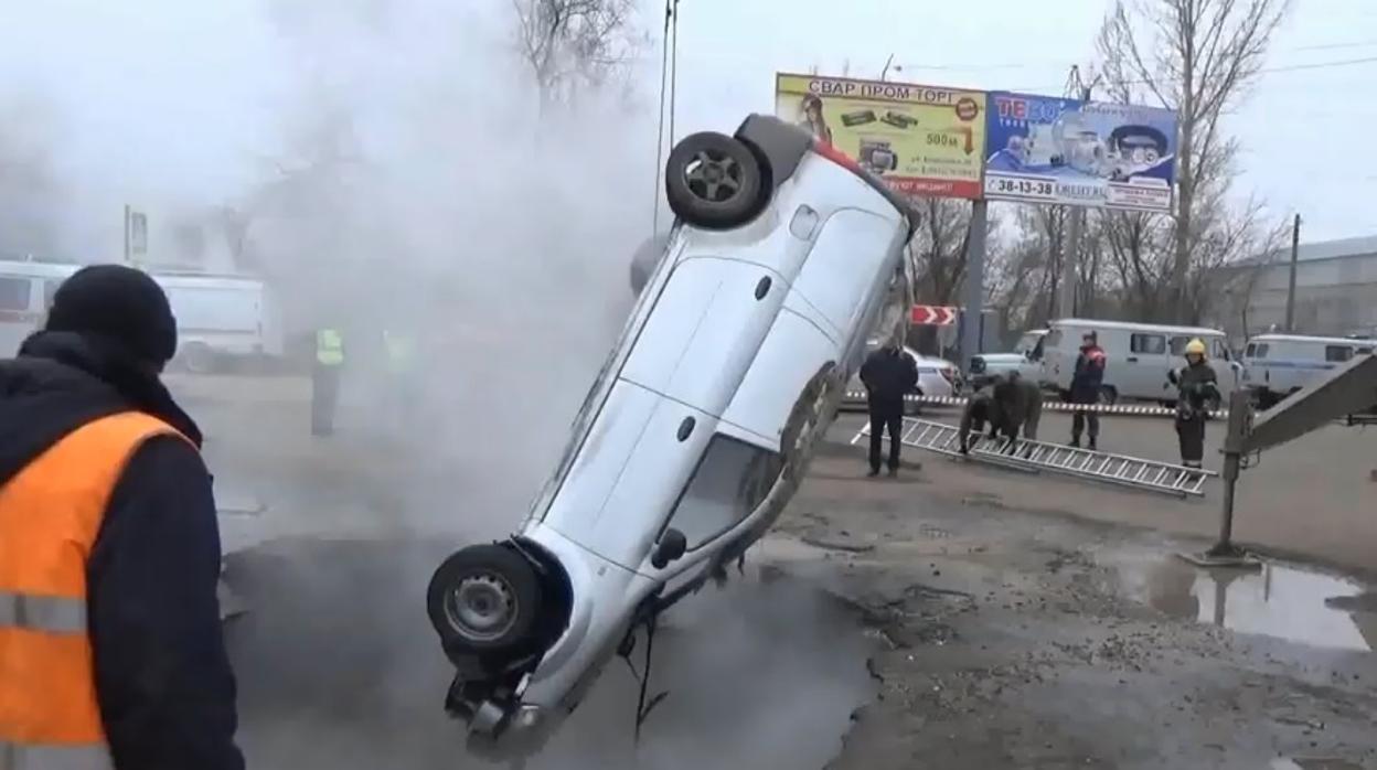 Momento en el que las autoridades sacan el vehículo del socavón