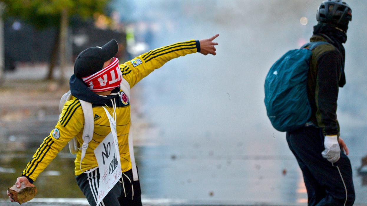 Un manifestante lanza una piedra a la Policía durante las protestas en Colombia