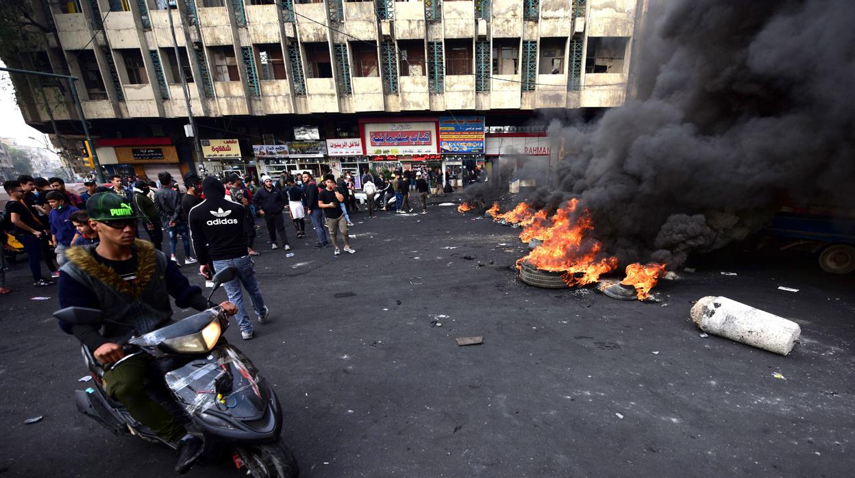 Manifestantes queman neumáticos en el centro de Bagdad