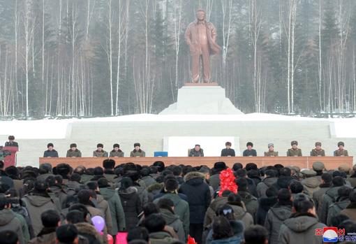 El líder norcoreano sentado con altos cargos de su Gobierno debajo de la estatua de su padre