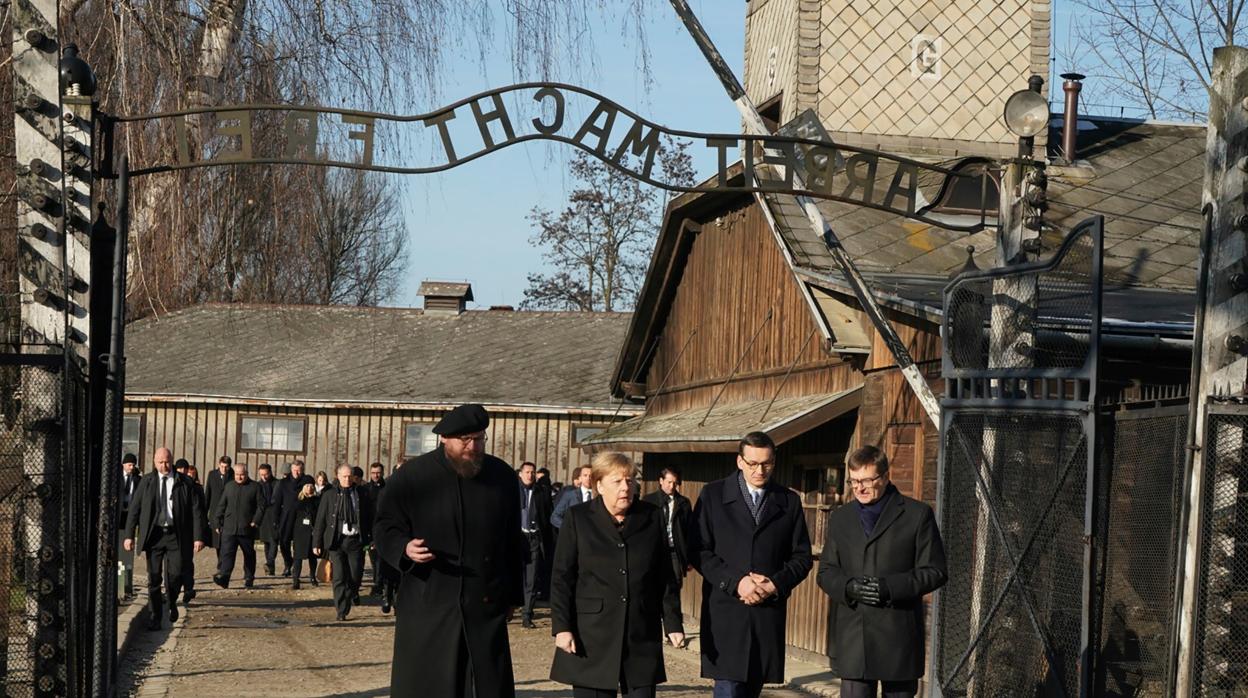 Angela Merkel, junto al primer ministro polaco, Mateusz Morawiecki, a la entrada al campo de Auschwitz