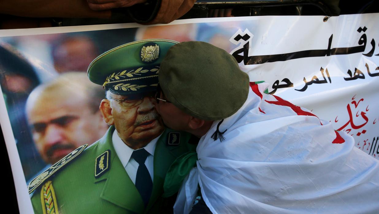 Un hombre besa la imagen del fallecido general Ahmed Gaid Salah durante los funerales en Argel