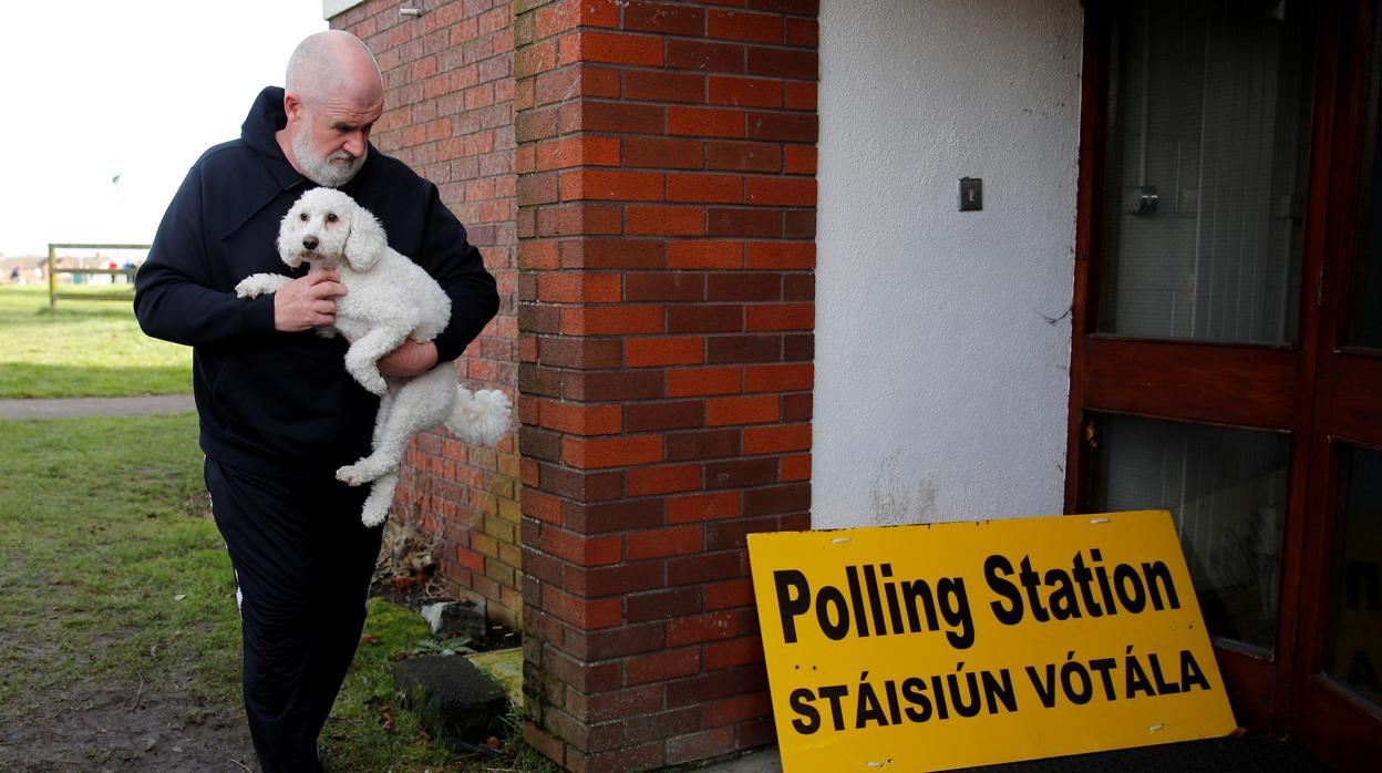 UN hombre acude a votar, llevando a su perro, a un colegio electoral en Dublín