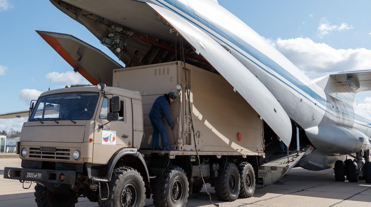 Un camión descarga material en uno de los av iones militares que viajarán el lunes a Italia