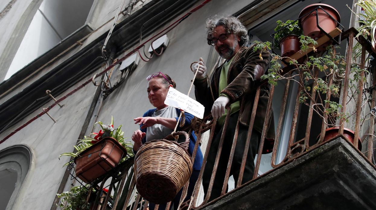 Vecinos confinados de Nápoles utilizan un sistema con cestas para donar y recibir comida