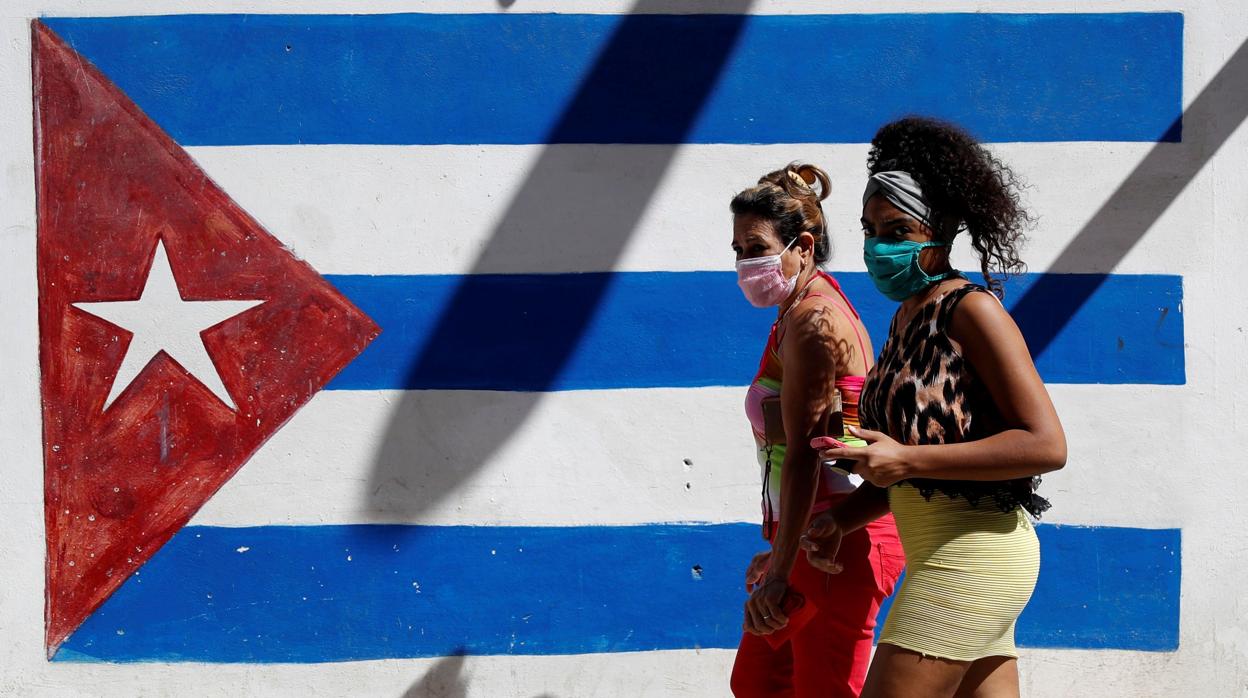 Dos cubanas caminan con una mascarilla por La Habana