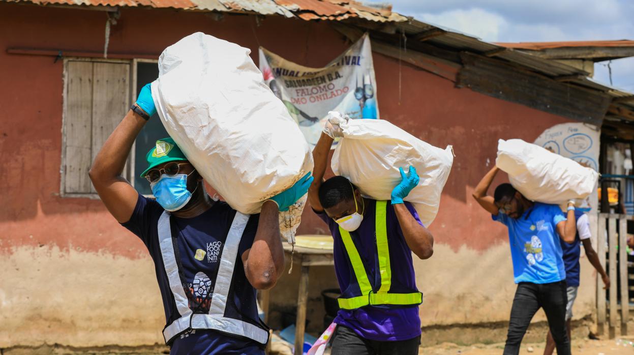 Voluntarios cargan sacos de comida para distrubuir en una población vulnerable en Nigeria