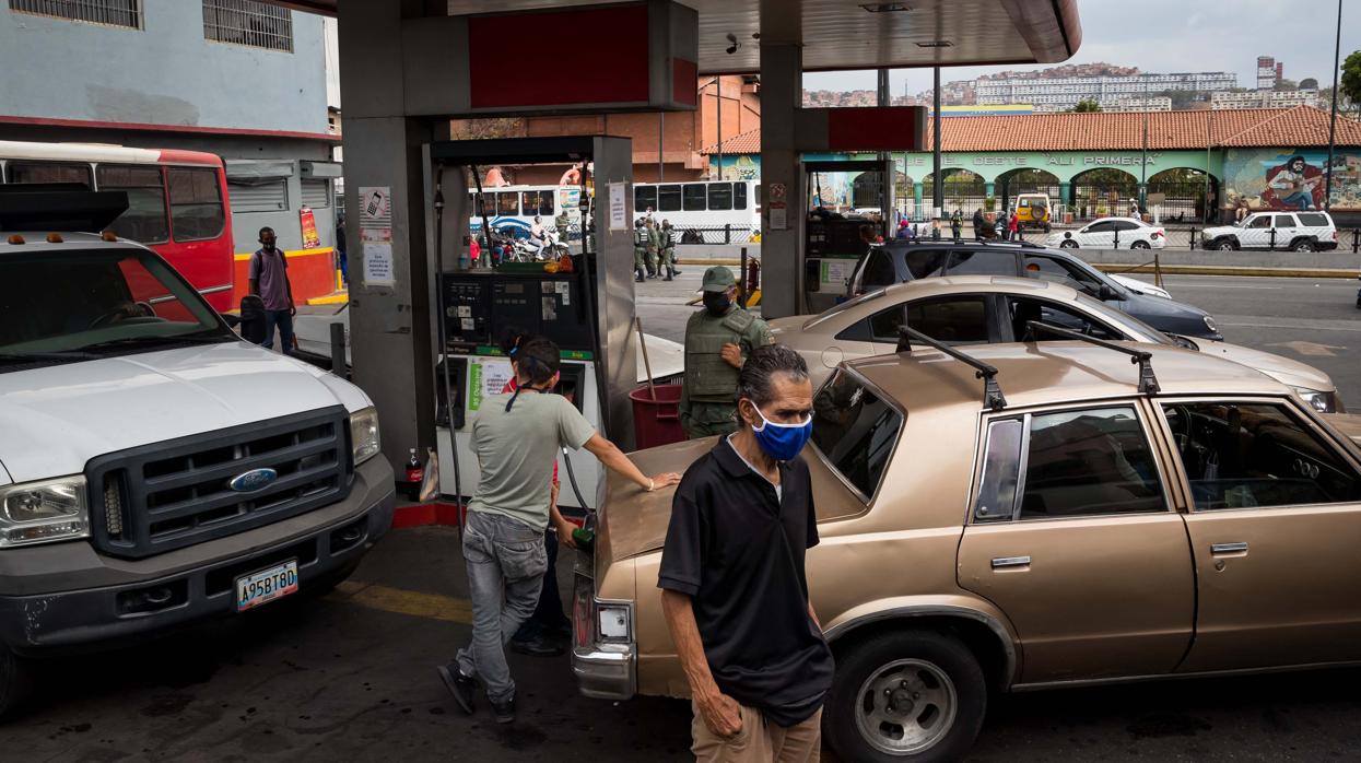 Varias personas cargan los depósitos de vehículos en Caracas