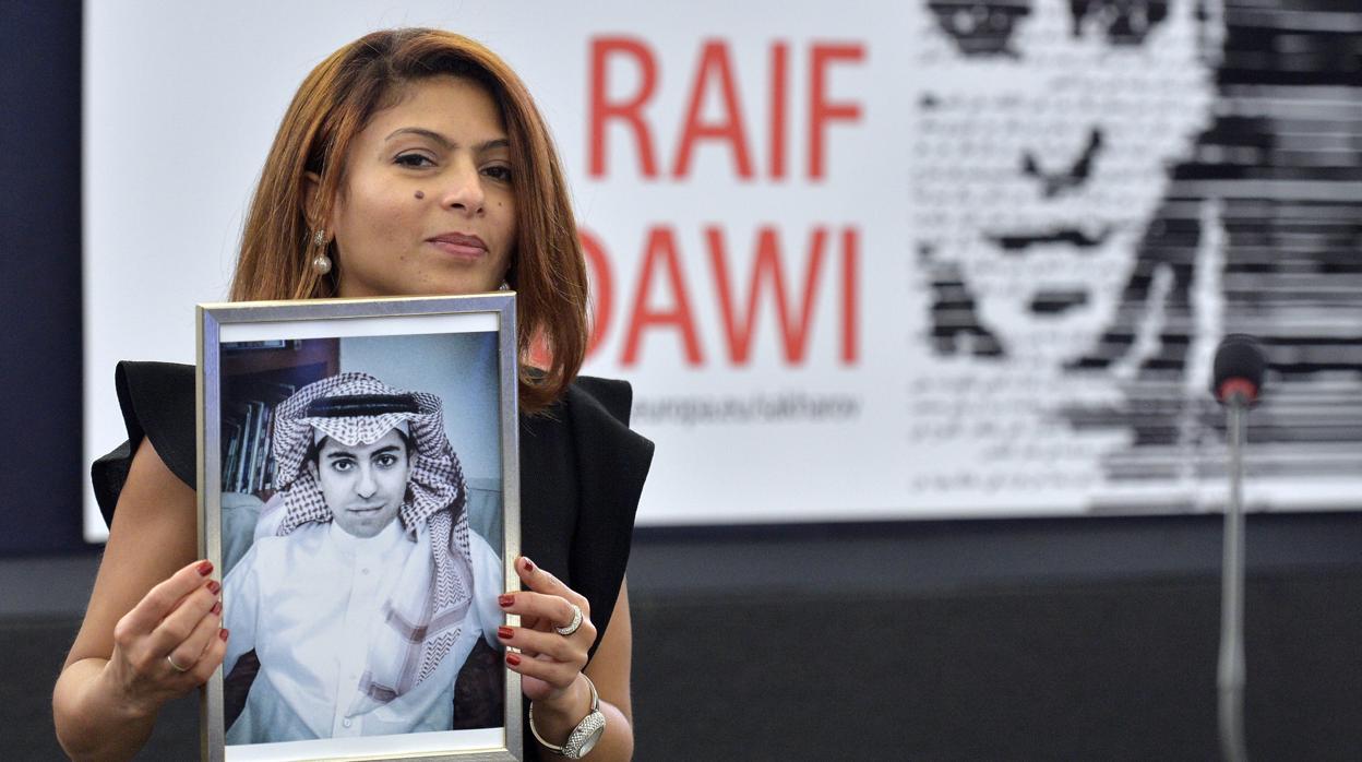 La esposa del periodista saudí Raif Badawi sostiene el retrato de su esposo, encarcelado por informar