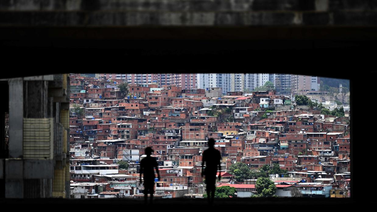 Un hombre y los suyos permanecen en el techo de un edificio a medio hacer del poder judicial en el barrio de Petare