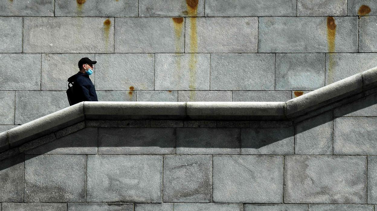 Un hombre protegido con una mascarilla sube unas escaleras en Moscú