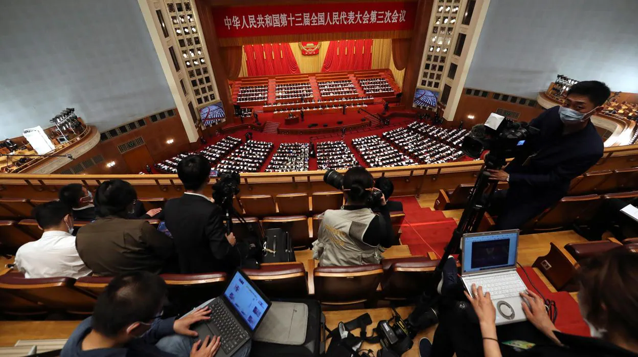 Los periodistas con mascarillass cubren la sesión de apertura del Congreso Nacional del Pueblo de China, en Beijing
