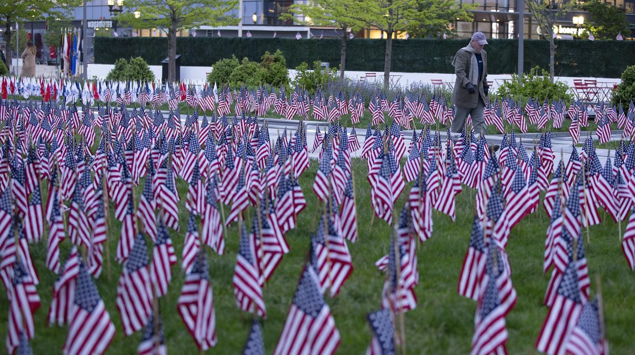 Un hombre camina entre las banderas de un homenaje a las víctimas del coronavirus en Boston