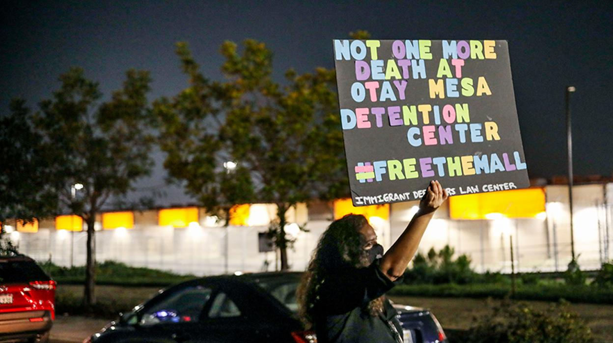 Una mujer sostiene un cartel que reclama que no haya más muertes en el centro de detención de Otay Mesa