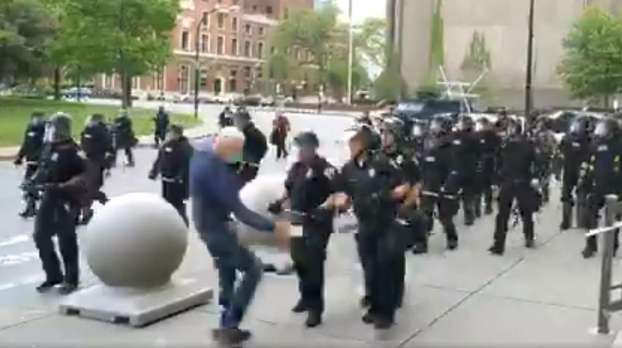 Momento en que el hombre se tambalea antes de caer al suelo tras el empujón de los agentes