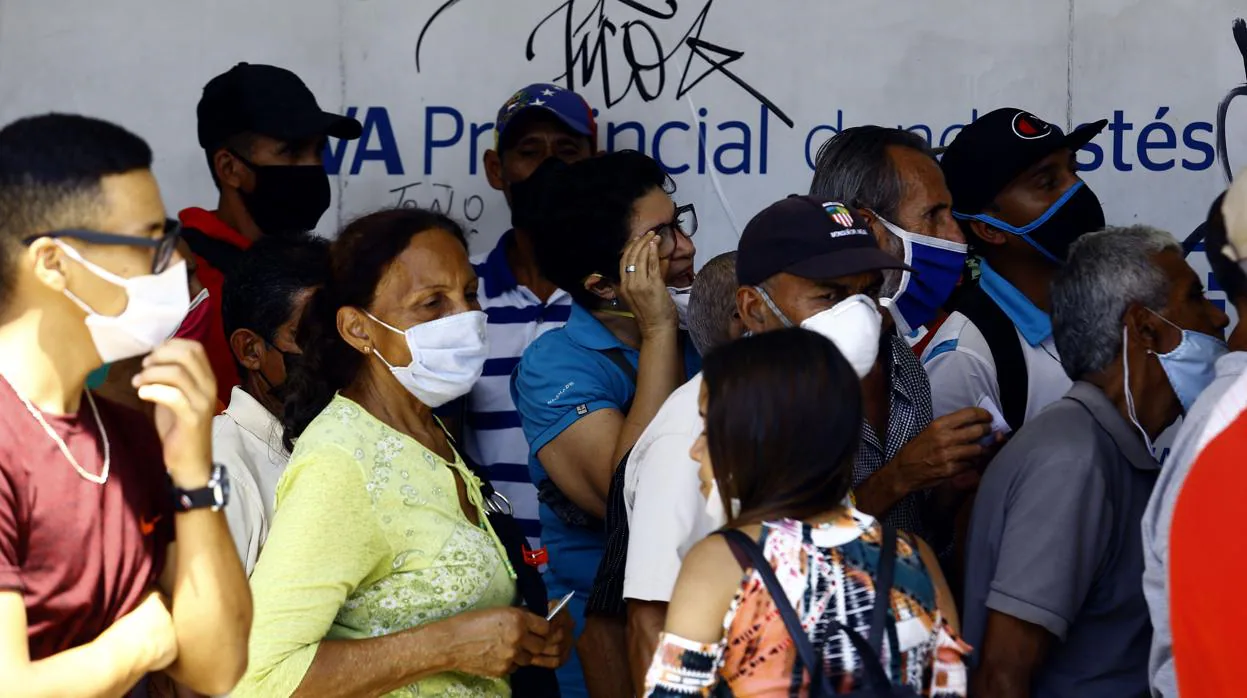 Un grupo de venezolanos se agolpa para entrar en un banco en la localidad de Valencia